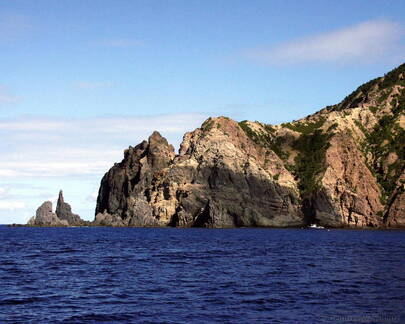 Dive Boat Dwarfed by Cliffs